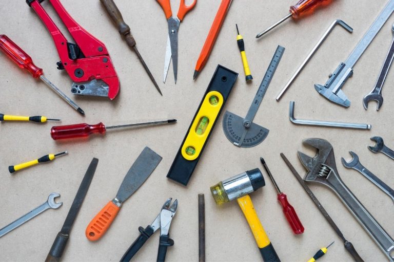 A collection of various tools, including pliers, wrenches, and additional hand tools, arranged on a workbench.